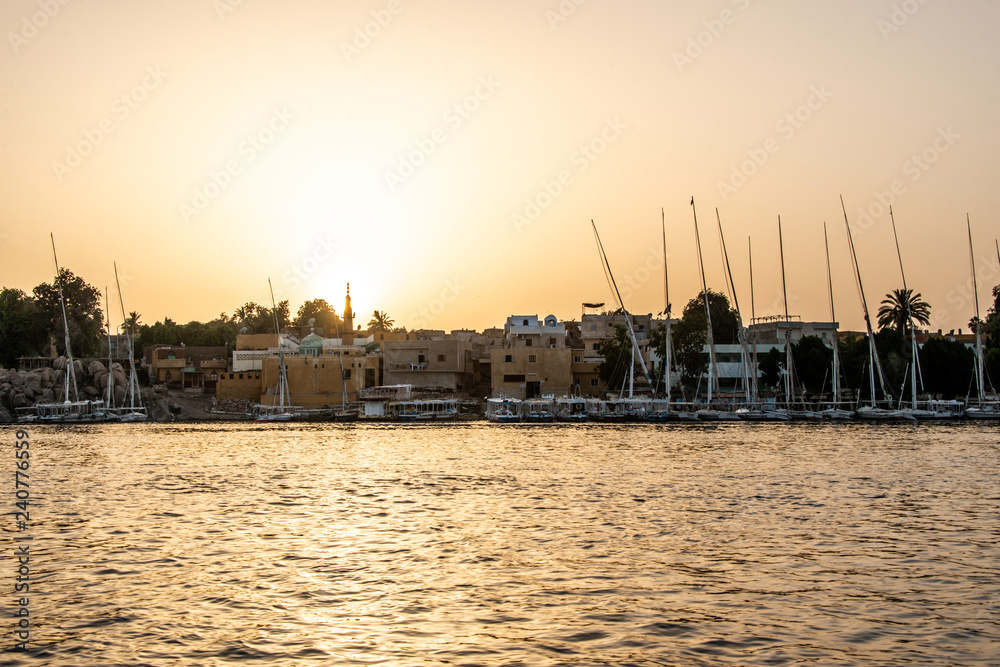sunset Nile Aswan the West Bank with small village houses with fishing sailing boats felucca