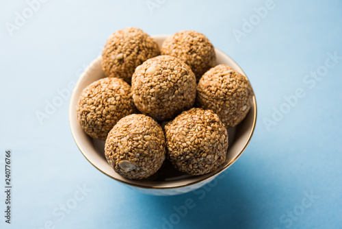 Tilgul Laddu or Til Gul balls for makar sankranti, it's a healthy food made using sesame, crushed peanuts and jaggery. served in a bowl. selective focus showing details.