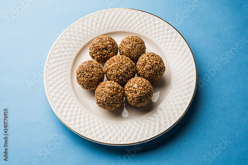 Tilgul Laddu or Til Gul balls for makar sankranti, it's a healthy food made using sesame, crushed peanuts and jaggery. served in a bowl. selective focus showing details.