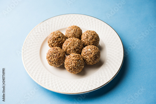 Tilgul Laddu or Til Gul balls for makar sankranti, it's a healthy food made using sesame, crushed peanuts and jaggery. served in a bowl. selective focus showing details.