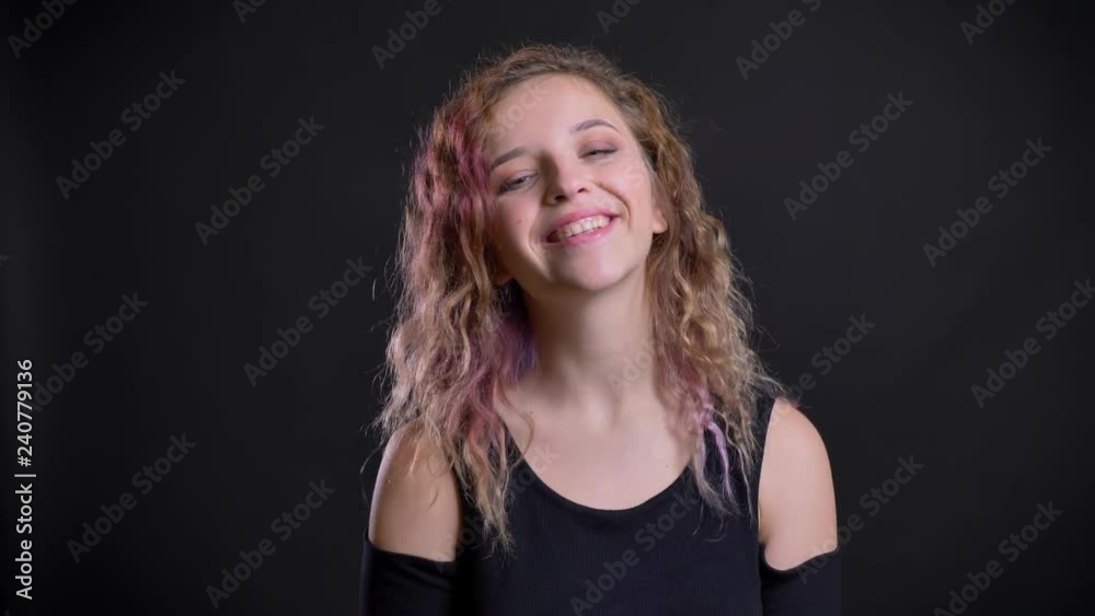 Portrait of young caucasian girl with pink hair jumping in great happiness on black background. Portrait of young caucasian girl with pink hair jumping in great happiness on black background.