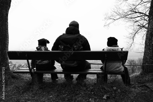 Vater und Söhne sitzen auf einer Bank