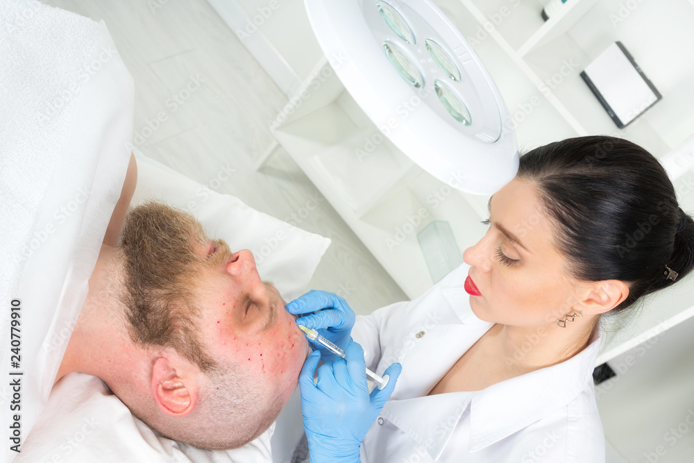 Fototapeta premium The doctor cosmetologist makes the Rejuvenating facial injections procedure for tightening and smoothing wrinkles on the face skin of a men in a beauty salon.Cosmetology skin care.