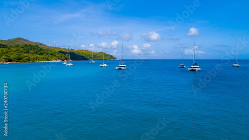 Spectacular aerial view of some yachts and small boats floating on a clear and turquoise sea, Seychelles in the Indian Ocean.Top view from drone