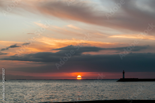 Sol poniéndose en el mar con espigón de puerto en primer término © joymafotografia