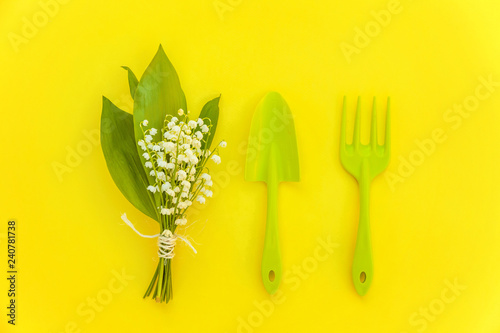 Flat Lay gardening tools, shovel, rake, flowers on yellow colourful trendy background. Spring or summer in garden, eco, nature, farm, horticulture hobby concept photo