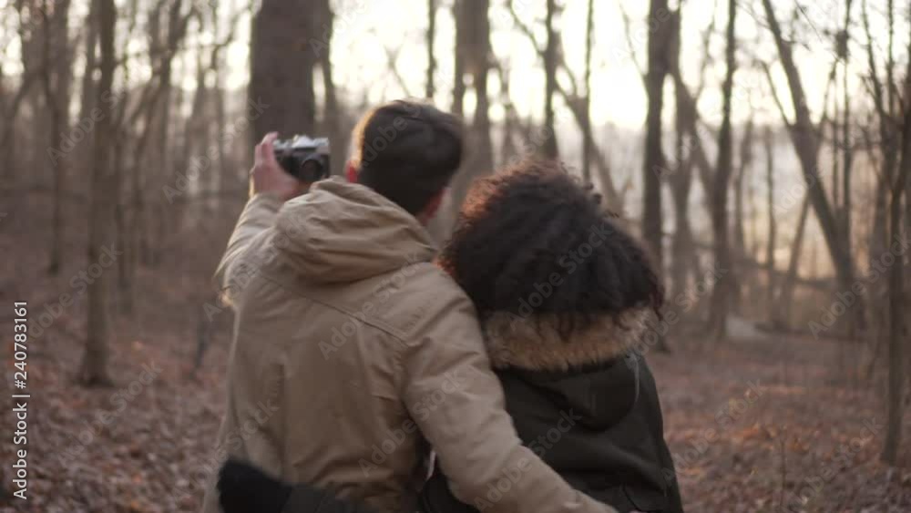 Couple taking self portrait using digital camera at forest Couple taking self portrait using digital camera at forest