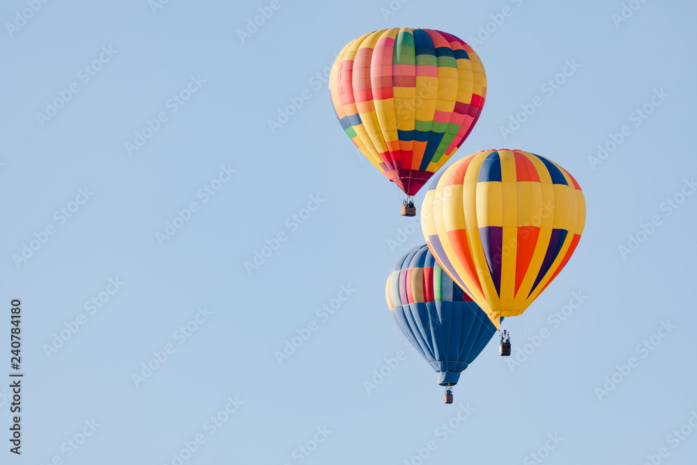 Naklejka premium Multi colored hot air balloons flying over blue sky