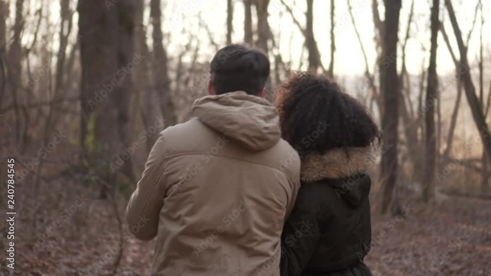 Couple strolling and photographing in forest during winter holiday Couple strolling and photographing in forest during winter holiday