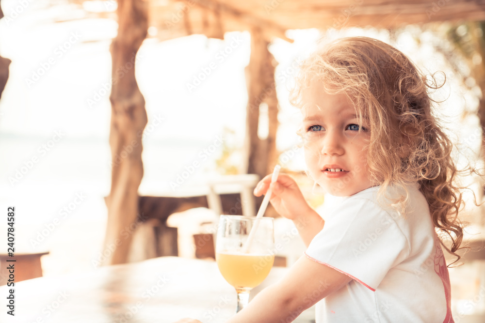 cute beautiful child girl enjoy drinking fresh juice in hot summer day looking into the distance during summer beach holidays with copy space cute beautiful child girl enjoy drinking fresh juice in hot summer day looking into the distance during summer beach holidays with copy space
