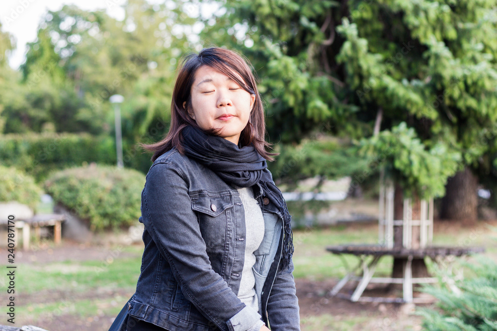 Chinese Girl Standing on the Wooden Bridge and Enjoying Sunny Day in a Park Chinese Girl Standing on the Wooden Bridge and Enjoying Sunny Day in a Park
