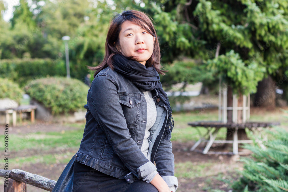 Chinese Girl Standing on the Wooden Bridge and Enjoying Sunny Day in a Park Chinese Girl Standing on the Wooden Bridge and Enjoying Sunny Day in a Park