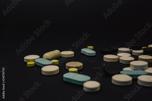 Pile of several medicines on black background