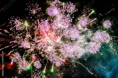 multicolored light bursts creating fireworks against a dark night sky