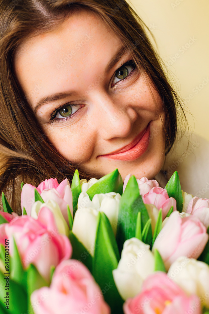 Beautiful stylish girl with pink tulips on white background. sensual looking eyes of young woman and flowers. natural beauty. skin care. spring bride bouquet. happy women's day. Beautiful stylish girl with pink tulips on white background. sensual looking eyes of young woman and flowers. natural beauty. skin care. spring bride bouquet. happy women's day.