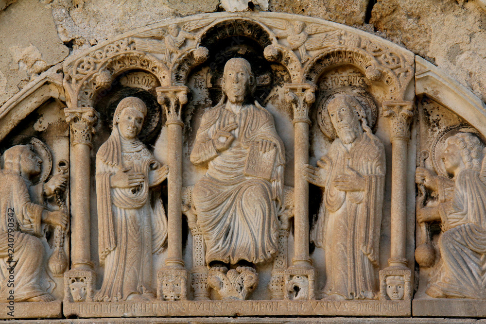 Cristo tra Maria, San Giovanni Battista e due angeli. Altorilievo; lunetta del portale romanico di una chiesa in abbandono a Barletta