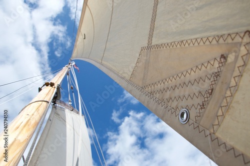 Looking up the mast on a sailing yacht; focussed on an eyelet in the sail