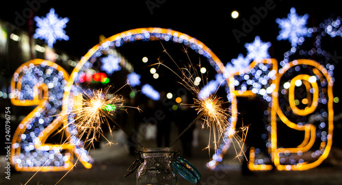 The inscription 2019 in Rasfokus, sparkler in the foreground, the concept of the new year photo