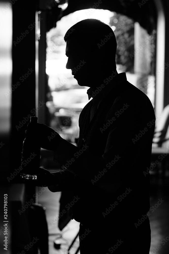 Man with bottle of wine at the dark tunnel