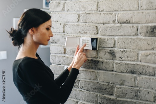 Obraz na płótnie Young woman entering security pin on home alarm keypad. w salonie