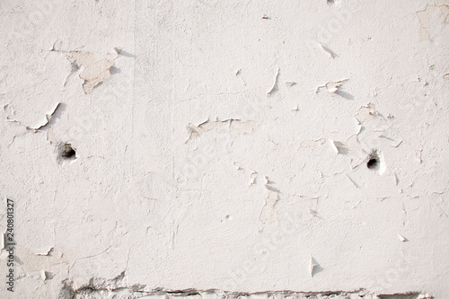 White  cracked wall with  bullet holes. War conception