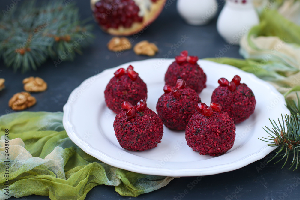 Traditional Georgian appetizer pkhali from beets, walnuts and pomegranate. Located on a white plate against a dark background Traditional Georgian appetizer pkhali from beets, walnuts and pomegranate. Located on a white plate against a dark background