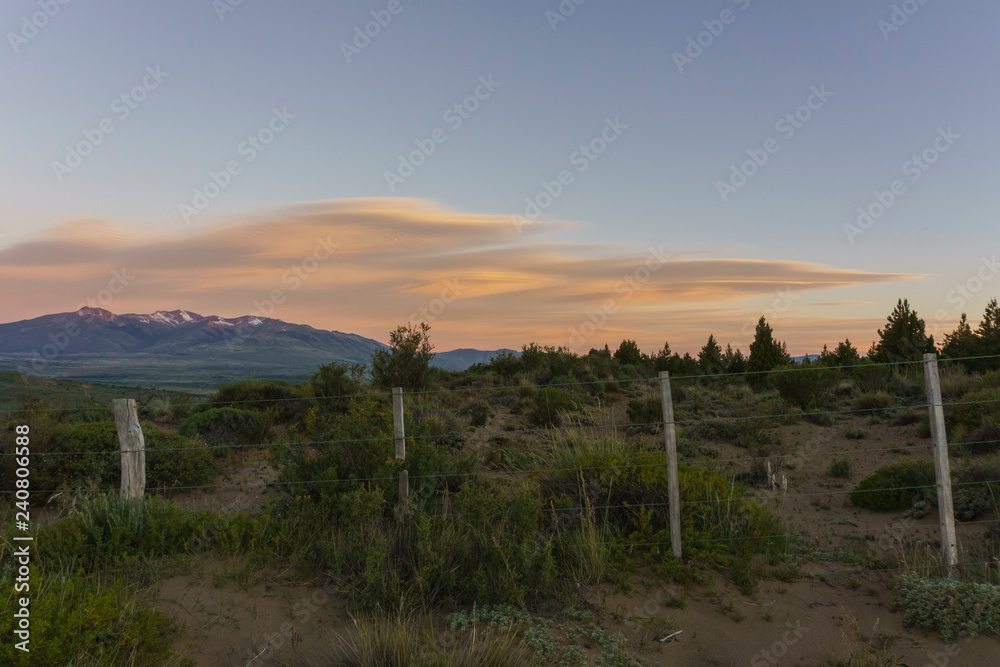 Orange lenticular clouds on sunset during spring season in Patagonia.