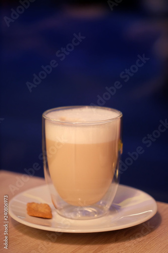 Cup of latte macchiato on dark-blue background.