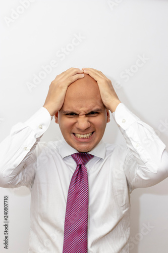 Angry bald man with hands on his head