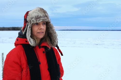 Portrait of a woman wearing a fur aviator hat and a red jacket in the winter weather
