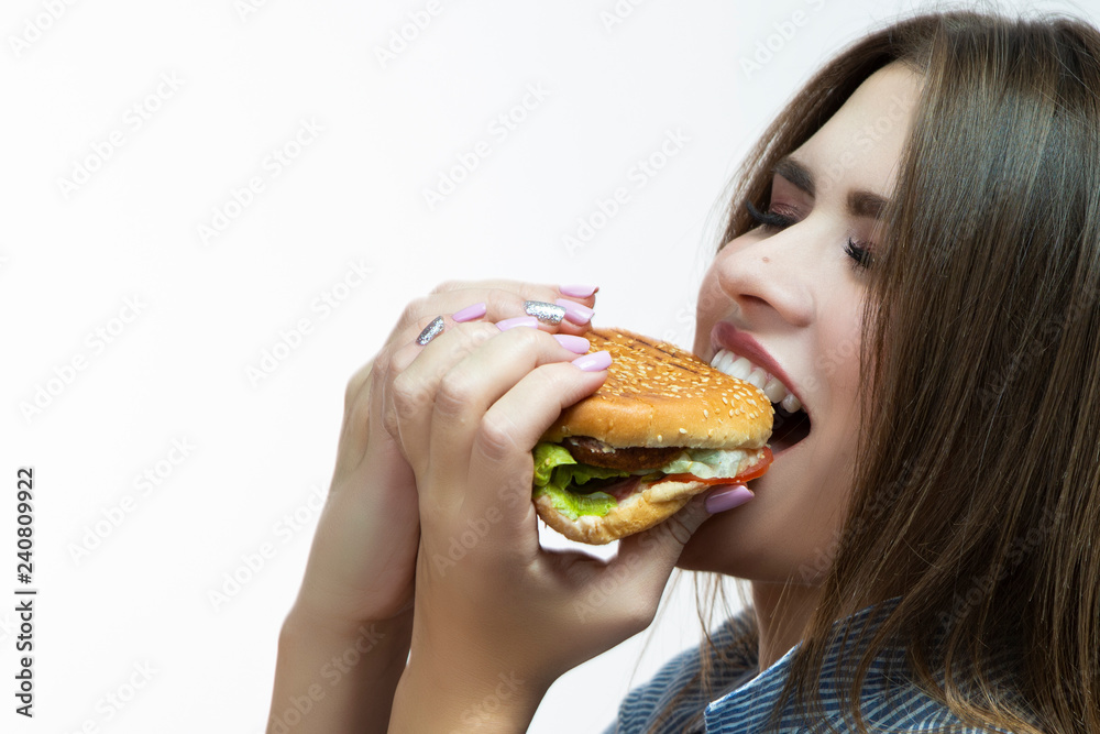 Unhealthy Eating Concepts. Closeup of Caucasian Woman Eating Burger. Profile Face View. Posing in Striped Shirt Indoors in Studio.