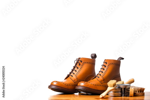 Mens Brogues Boots In Line With Cleaning Accessories on Shiny Table.Against White.