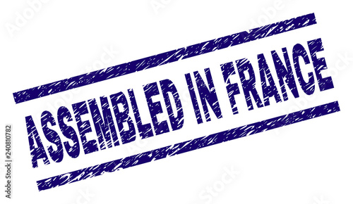 ASSEMBLED IN FRANCE seal print with distress style. Blue vector rubber print of ASSEMBLED IN FRANCE text with unclean texture. Text label is placed between parallel lines.