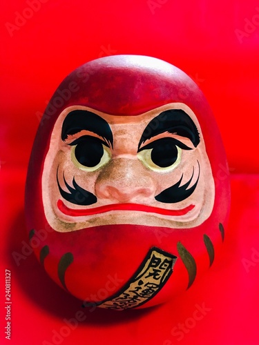 Red Daruma (Japanese lucky charm) on red background photo
