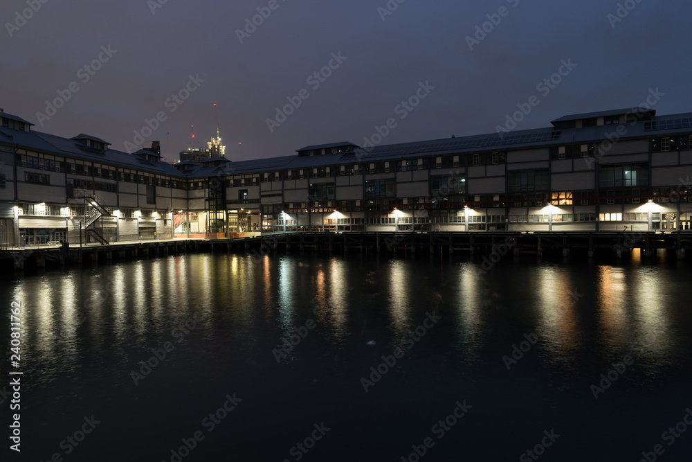 waterfront warehouse at night with city in background