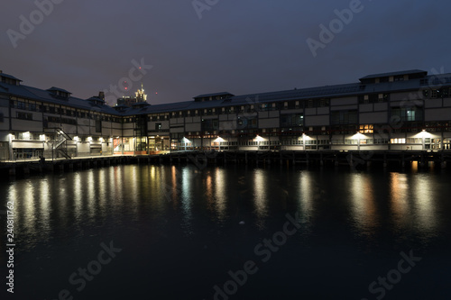 waterfront warehouse at night with city in background