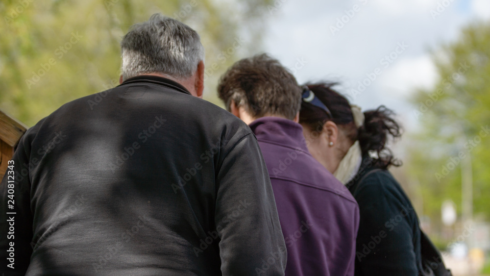 Drei Personen von hinten, die auf etwas schauen Drei Personen von hinten, die auf etwas schauen
