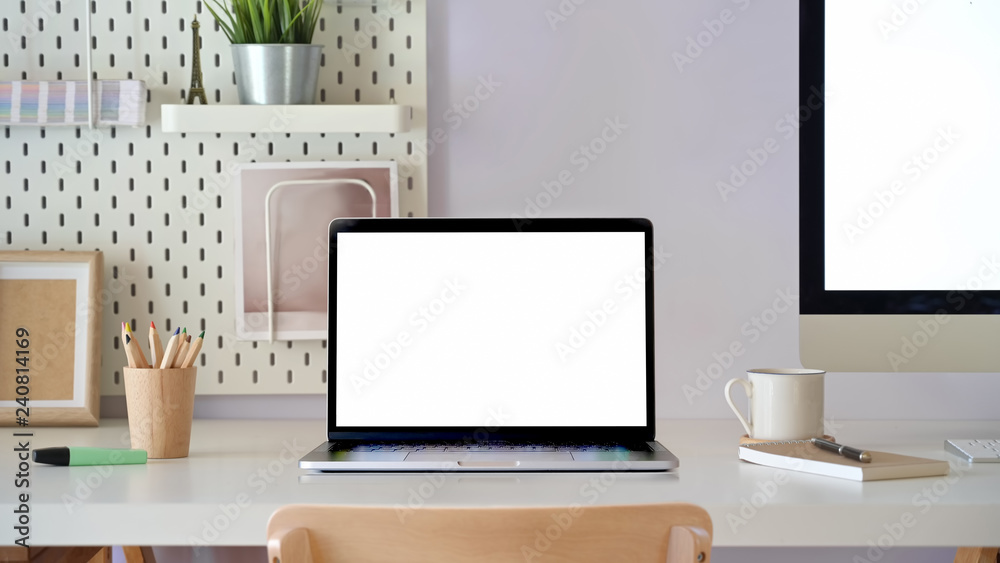 Fototapeta premium Office desk scenery with mockup blank screen laptop computer. Workspace minimal