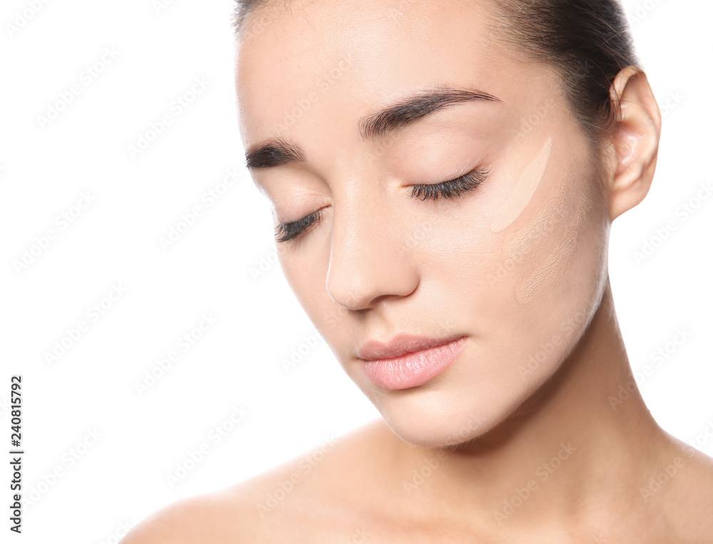 Young woman with different shades of skin foundation on her face against white background Young woman with different shades of skin foundation on her face against white background