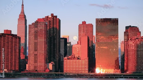 View on midtown Manhattan with full moon from East river at sunrise photo