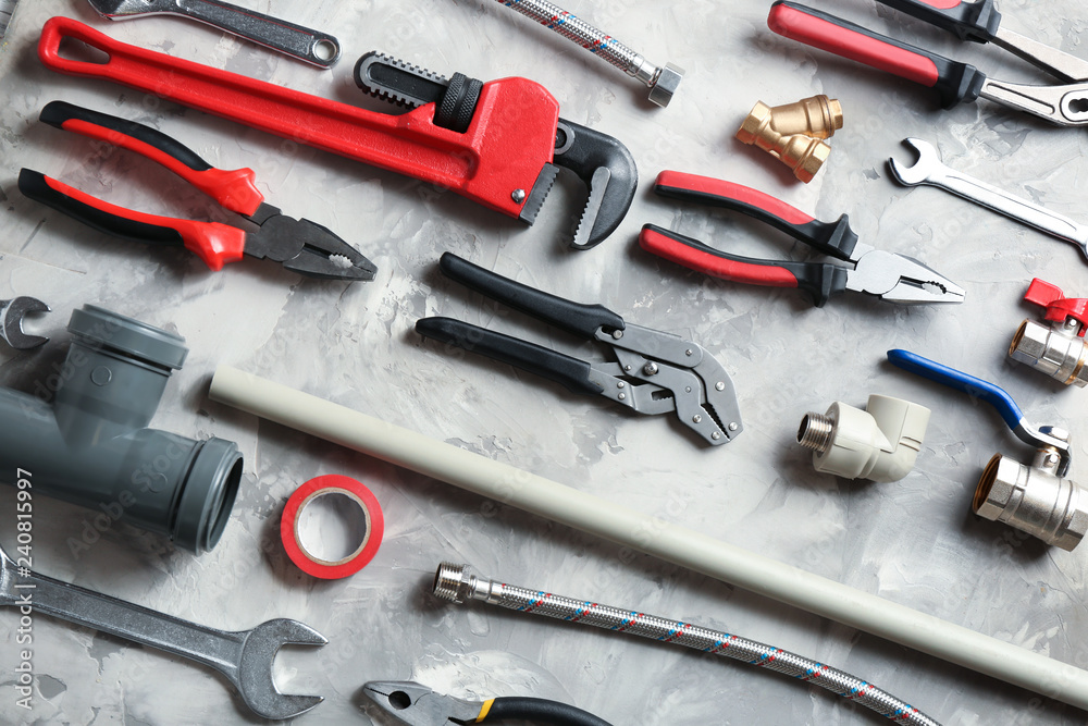 Flat lay composition with plumber's tools on grey background Flat lay composition with plumber's tools on grey background