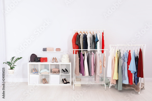 Racks with clothes in stylish dressing room interior