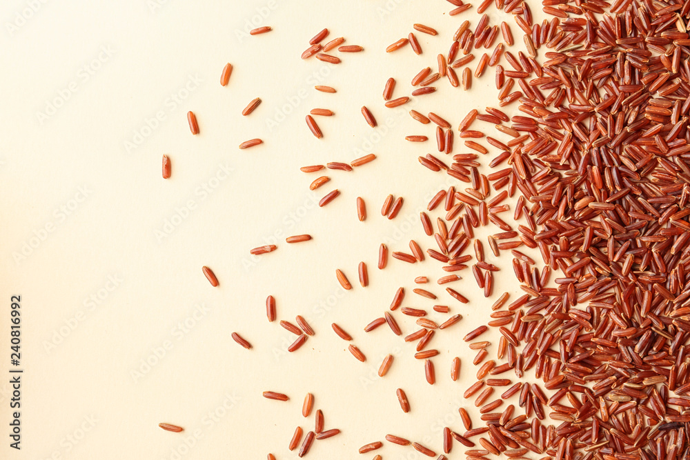 Naklejka premium Brown rice on color background, top view with space for text