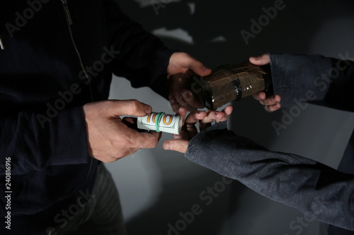 Addicted man buying drugs from dealer, focus on hands