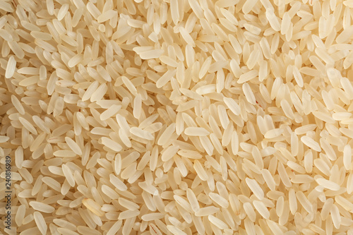 Raw parboiled rice as background, closeup view photo