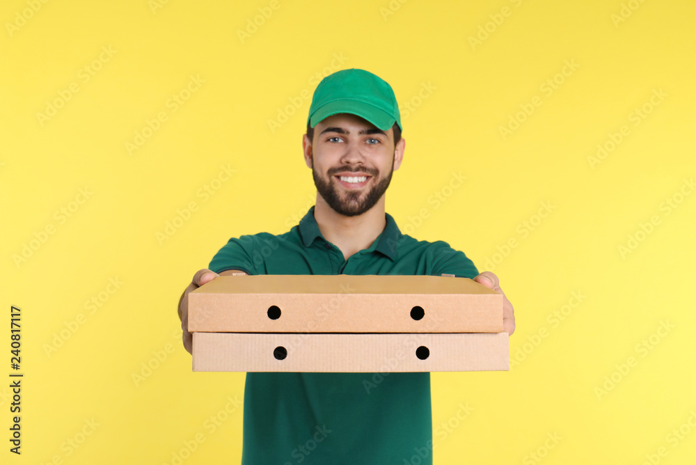 Young courier with pizza boxes on color background. Food delivery service Young courier with pizza boxes on color background. Food delivery service