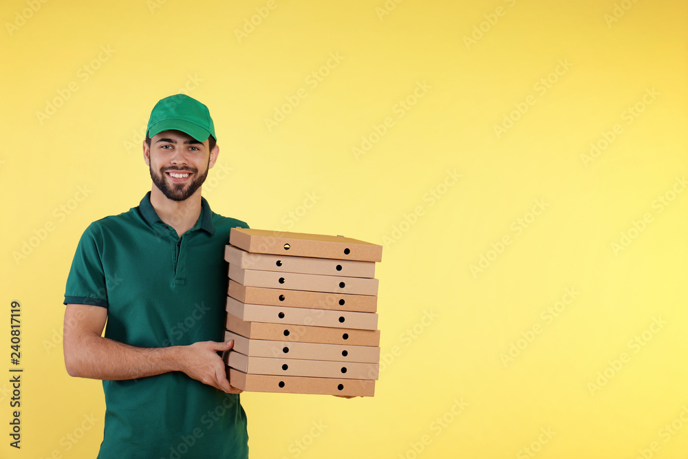 Young courier with pizza boxes on color background, space for text. Food delivery service Young courier with pizza boxes on color background, space for text. Food delivery service