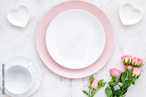 set-up table with plates, heart-shaped saucer and flower on white background top view mock-up