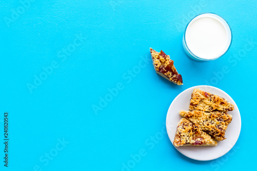 Children tradition evening dessert. Milk and homemade cookies on blue background top view space for text