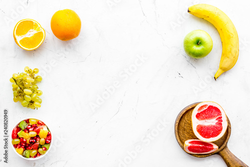 Fototapeta Naklejka Na Ścianę i Meble -  Healthy diet concept. Fruit salad near fresh fruits on white background top view copy space